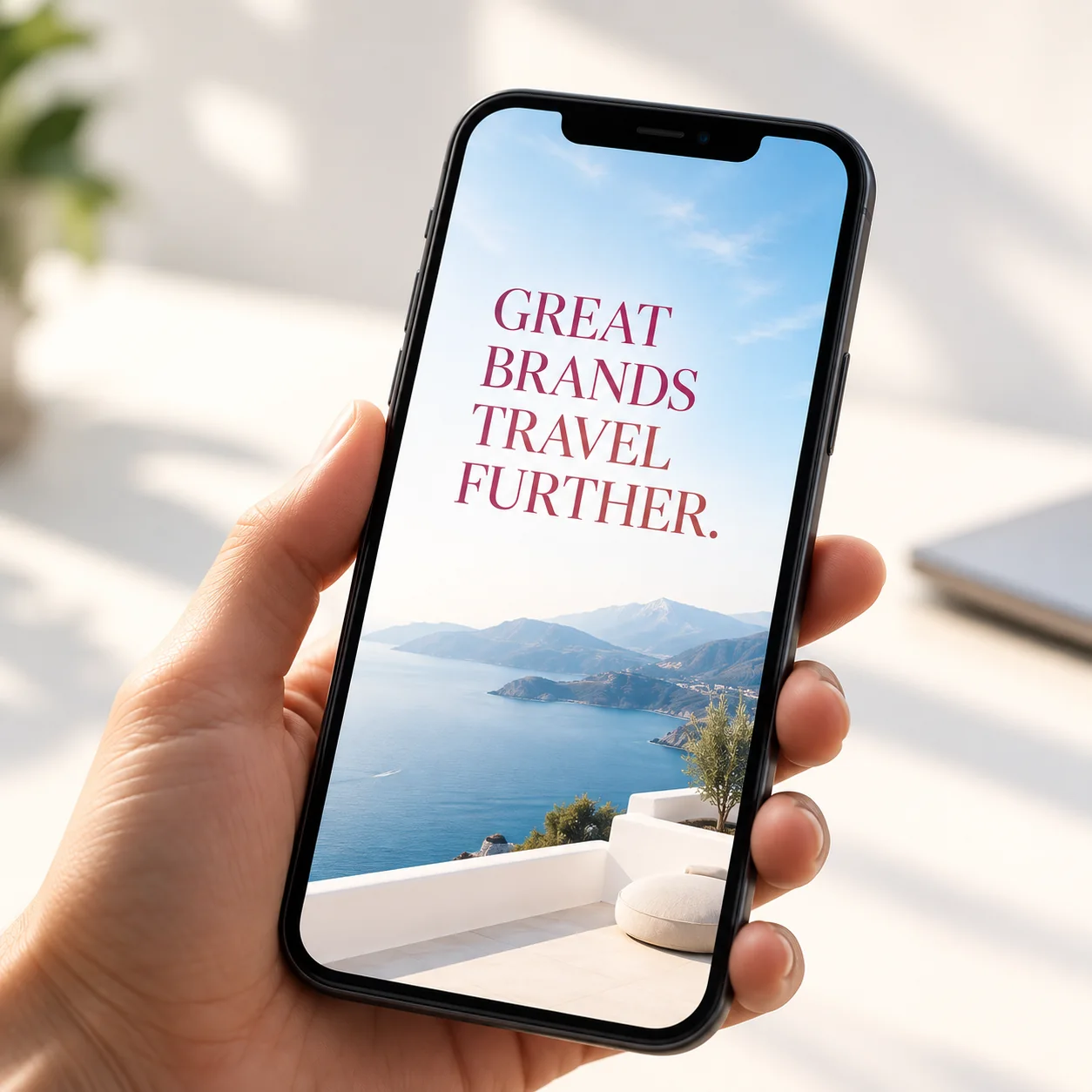 Hand holding a phone showing: Great brands travel further.